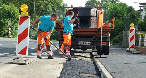 Das Foto zeigt Mitarbeiter des DBM beim Ausbessern einer Straße mit Heißasphalt.&nbsp;&copy;&nbsp;DBM, Sonja Stender