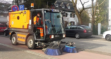 Das Foto zeigt ein Bürgersteigkehrfahrzeug beim Reinigen des Radweges in der Schulstraße.