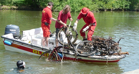 Das Foto zeigt Freiwillige der DLRG, die ein Fahrrad aus der Lahn in ein Motorboot hieven.&nbsp;&copy;&nbsp;DBM, Sonja Stender