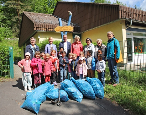 Eine Gruppe von Menschen steht vor einem Haus. Vor ihnen liegen gefüllte blaue Müllsäcke.&nbsp;&copy;&nbsp;Stefanie Ingwersen, Stadt Marburg