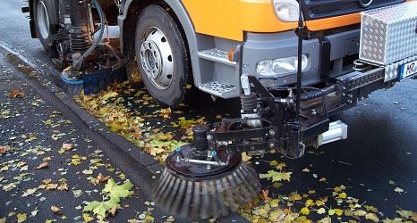 Das Foto zeigt das Kehrwerk einer großen Kehrmaschine beim Aufkehren von Laub.&nbsp;&copy;&nbsp;DBM, Sonja Stender