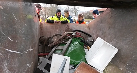 Das Foto zeigt Aktive des Sauberhaften Frühjahrsputz in Elnhausen wie sie in die gefüllte Abfallmulde schauen.&nbsp;&copy;&nbsp;DBM